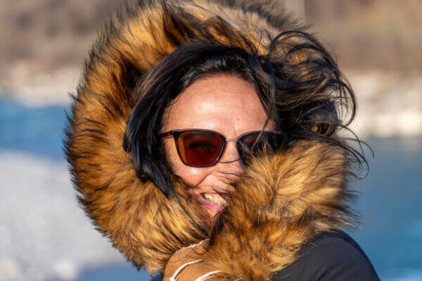 Portrait of a woman in winter clothes and sunglasses.