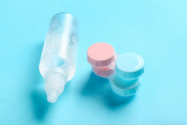 Containers for contact lenses with solution on blue background
