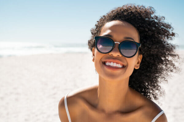 Woman wearing sunglasses at the beach. 