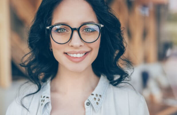 Head shot image is of a woman wearing prescription eyeglasses smiling.